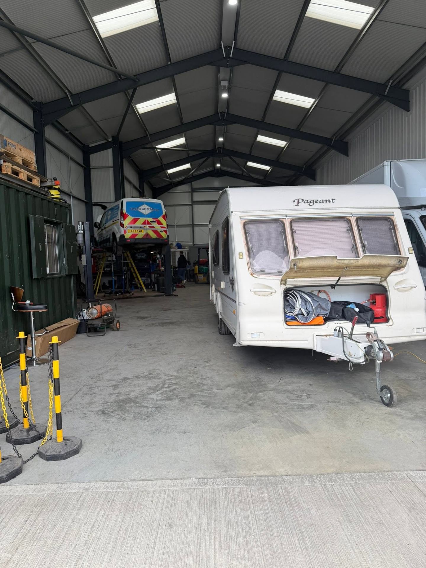 Mechanic working on a van on a two-post lift inside the Knight's Car & Van Repairs workshop