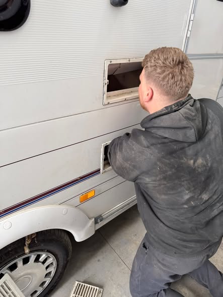 Touring caravan receiving mechanical repairs inside the workshop